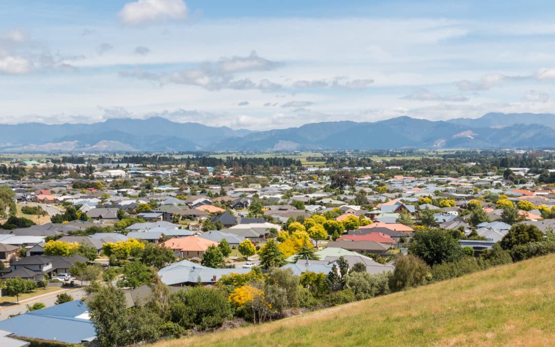 A view of a city with houses and mountains in the background