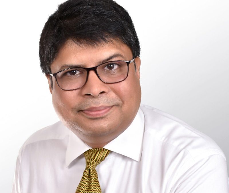 A man wearing glasses and a yellow tie