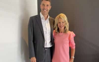 A man and woman posing in front of a wall