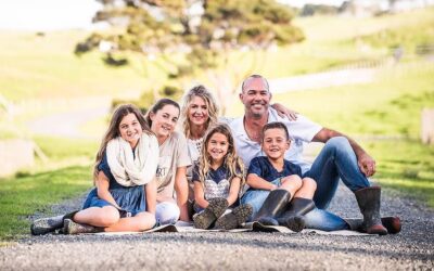 A family sits on a road in a country setting