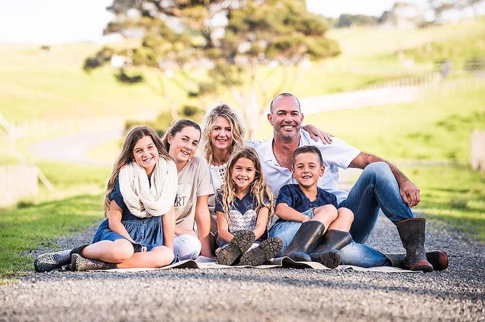 A family sits on a road in a country setting