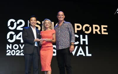 Two men and a woman standing on a stage at a tech festival